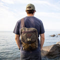 A man wearing a waxed canvas cross body bag.