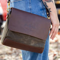 Woman carrying a waxed canvas and leather shoulder bag