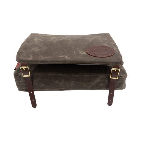 A waxed canvas canoe seat pad that has an attached bag that hangs underneath the canoe seat. 