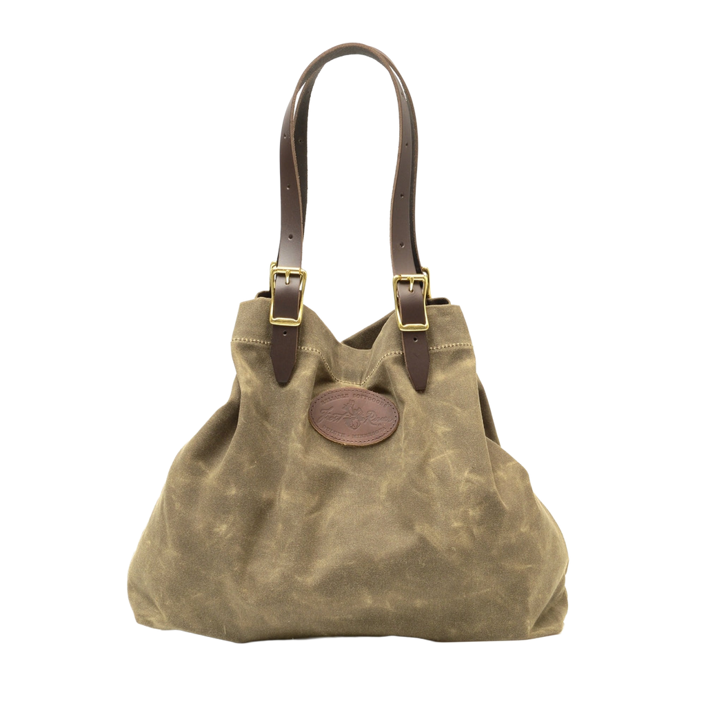 Large tote with adjustable leather straps connected with solid brass buckles.