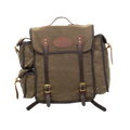 A waxed canvas backpack with dark brown leather straps and trim, featuring a central flap pocket with brass-tone buckles and a circular leather logo patch.