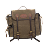 A waxed canvas backpack with dark brown leather straps and trim, featuring a central flap pocket with brass-tone buckles and a circular leather logo patch.