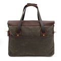The backside of a waxed canvas and leather shoulder strap showing off the large slip pocket. 