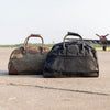 Waxed canvas and leather duffel bag sitting on an airstrip waiting for a plane. 
