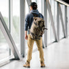 A man wearing the Explorer Duffel ESB which is a waxed canvas duffle bag equipped with back straps. 