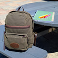 Frost River's North Bay Backpack sitting at a park bench with a notebook and highlighters. 