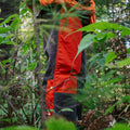 Two Tone Hunting Chaps standing in the thick woods.